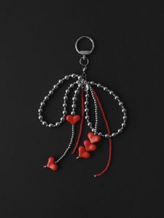 a keychain with hearts hanging from it's side on a black surface