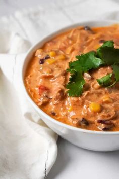 a white bowl filled with soup and garnished with cilantro