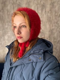 a woman wearing a red hat and blue coat