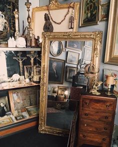 there are many framed pictures on the wall next to a dresser and mirror in this room