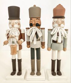 three wooden nutcrackers with hats and tails