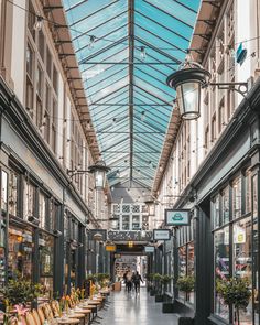 the inside of a shopping mall with tables and chairs on either side of the walkway