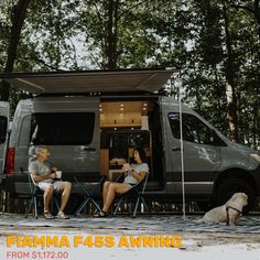 two people sitting at a table in front of a van with the words flamma fass awning on it