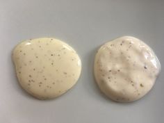 two cookies with white icing sitting on top of each other