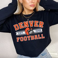 Perfect sweatshirt for Denver Bronco football fans this season! Ideal for any situation, a unisex heavy blend crewneck sweatshirt is pure comfort. These garments are made from polyester and cotton. This combination helps designs come out looking fresh and beautiful. The collar is ribbed knit, so it retains its shape even after washing. There are no itchy side seams on these sweaters.  .: 50% cotton, 50% polyester .: Medium-heavy fabric (8.0 oz/yd² (271.25 g/m .: Loose fit .: Sewn-in label .: Runs true to size CARE INSTRUCTIONS: -Please wash all clothing items INSIDE OUT to preserve the design. -Please wash all clothing items on cold, and dry on Medium- low heat. -DO NOT IRON. -DO NOT TIE DYE. **Please check our color and size charts before you place your order. If you have any questions pl Team Logo Sweatshirt For Sports Events In Fall, Football Season Fan Gear Sweatshirt With Graphic Print, Football Season Graphic Print Fan Gear Sweatshirt, Team-colored Long Sleeve Sweatshirt For Fans, Fan Apparel Sweatshirt With Team Logo For Sports Season, Crew Neck Sweatshirt With Team Logo For Fans, Sports Season Fan Apparel Sweatshirt, Sports Season Team Logo Sweatshirt, Team-colored Football Season Fan Sweatshirt