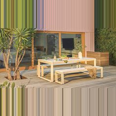 a wooden table sitting on top of a wooden floor next to a potted plant