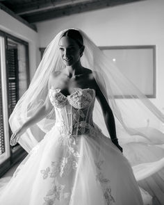 a woman in a wedding dress is posing for the camera with her veil over her head