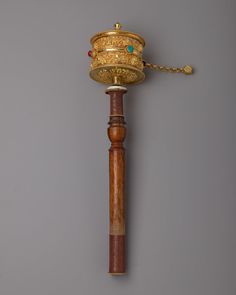 a wooden pole with a golden crown on it's top and chain attached to it