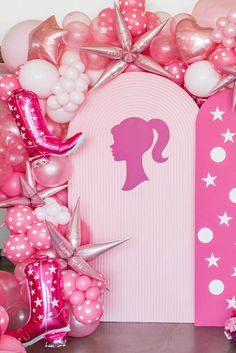 a pink backdrop with balloons, stars and a woman's head