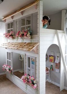 there is a doll house with flowers on the top and bottom floor in front of it