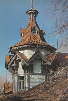 an old white house with a brown roof