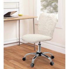 a white chair sitting in front of a desk with a laptop computer on top of it