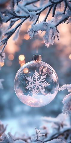 a snowflake ornament hanging from a tree with lights in the background