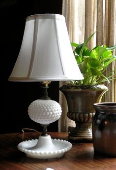 a table with a lamp, vase and other items on it