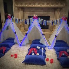 three teepee tents are set up in the middle of a room with pillows and blankets