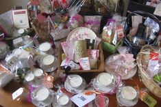 a wooden table topped with lots of baskets filled with candles and other items on top of it