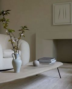 a vase with flowers is sitting on a coffee table in front of a white couch