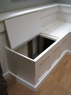 an empty kitchen with white cabinets and drawers