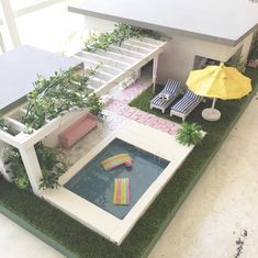 a doll house with lawn furniture and an umbrella