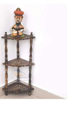 a three tiered shelf with a figurine on top