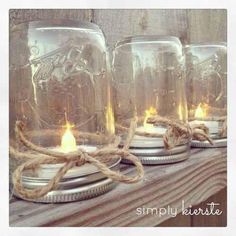 three mason jars sitting on top of a wooden shelf with rope wrapped around the lids