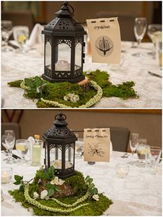 the table is decorated with moss and lanterns