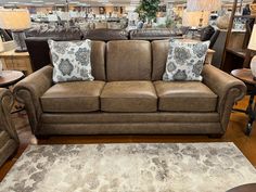 a brown couch with pillows on it in a store