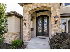 the front door of a home with two lights on it's side and an entry way