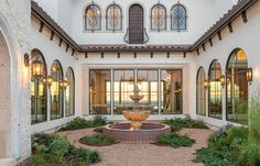 a large white building with a fountain in the middle of it's front yard