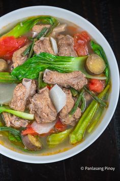 a white bowl filled with meat and vegetables