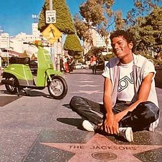 a man sitting on the hollywood walk of fame