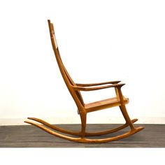 a wooden rocking chair sitting on top of a hard wood floor