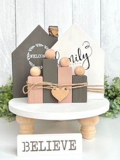 a small wooden house sitting on top of a white table next to a welcome sign