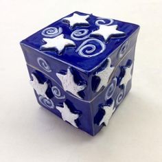 a blue and white ceramic object with stars on it's sides sitting on a table