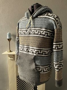 a knitted sweater is displayed on a mannequin