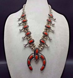 "VINTAGE NAVAJO SQUASH BLOSSOM NECKLACE DESCRIPTION: This stunning necklace features 18 oval cabochons of old red Mediterranean coral. The gemstones are secure in scalloped bezel, on a foundation of heavy gauge vintage sterling silver. Each blossom is framed with an applied leaf, applied raindrops, and a sterling silver swirl. This magnificent necklace will be a valuable addition to your collection of fine vintage Native American jewelry. MEASUREMENTS: Necklace measures 26\" end to end Naja meas Vintage Red Jewelry, Traditional Red Jewelry For Collectible, Traditional Red Jewelry For Collectors, Classic Handmade Red Necklace, Handmade Red Necklaces For Collectors, Red Handmade Necklace For Collectors, Southwestern Style Round Red Jewelry, Red Antique Collectible Jewelry, Vintage Oval Red Jewelry