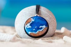 "Beautiful pendant of a coast seen from above with a round shape and a blue aqua color. This beach circle necklace with a Mediterranean style is perfect to wear with sporty and more formal attire in summer. A great gift for him, someone who loves the ocean so much. Each piece of round beach pendant is made with great finesse and no two are alike. So yours will be unique and special. Due to being handmade, the colors may vary slightly and there could be a slight difference from the photo. It is n Jewellery Summer, Beach Resin, Aqua Beach, Ocean Gifts, Shark Necklace, Ocean Necklace, Beach Necklace, Beach Necklaces, Blue Circle