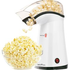 a pink electric popcorn maker next to a bowl full of popcorn and a white background