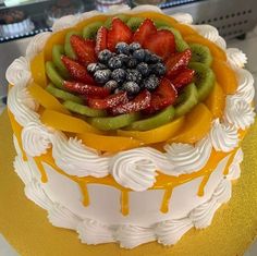 there is a cake that has fruit on the top and bottom layer with white icing