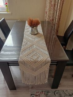 a table with a vase on top of it next to two chairs and a rug