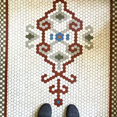 a person standing in front of a tiled floor with hexagonal designs on it