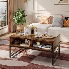 a living room with a couch, coffee table and potted plant in the corner