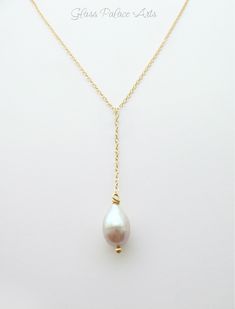 "Freshwater Pearl Lariat Teardrop Necklace~ Available in sterling silver, 14k gold fill or rose gold fill A touch of simple elegance and classic pearls are brought together to make this necklace. - A genuine ivory freshwater pearl teardrop - pearl is approx 12 - 14mm - Chain is a dainty and sparkling sterling silver, 14k gold fill, or rose gold chain - The length of the chain that goes around the neck not including the dangle section is shown at a 17\". You can choose a longer length during chec Delicate Yellow Gold Drop Necklace For Wedding, Gift Pearl Drop Lariat Necklace, White Gold Lariat Necklace For Wedding, Classic Yellow Gold Drop Necklace For Wedding, Wedding White Gold Lariat Necklace, Teardrop Yellow Gold Lariat Necklace Gift, Yellow Gold Teardrop Lariat Necklace Gift, Classic Long Drop Necklace For Weddings, Yellow Gold Pear Drop Necklace For Wedding