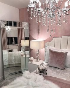 a bed room with a neatly made bed and a chandelier