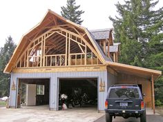 a truck is parked in front of a garage with an open roof and two large windows