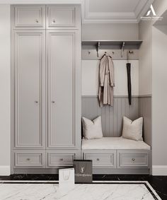 a white and gray closet with two coats hanging on the wall next to a bench