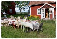 a table set up outside in front of a red barn