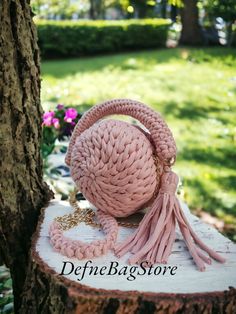 a pink purse sitting on top of a tree stump