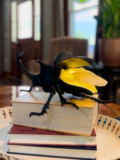 a yellow and black beetle sitting on top of a book in front of a table