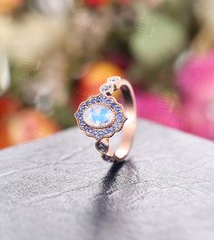 a close up of a ring on top of a table with flowers in the background